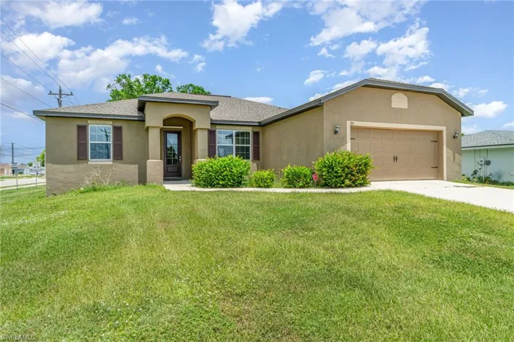 View of front of property featuring stucco siding, a front lawn, a garage, concrete driveway, and a shingled roof