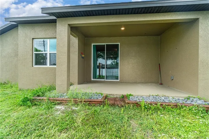 Rear view of house with stucco siding and a patio
