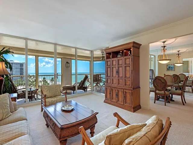 Living room area with floor to ceiling windows, a gulf view, and crown molding