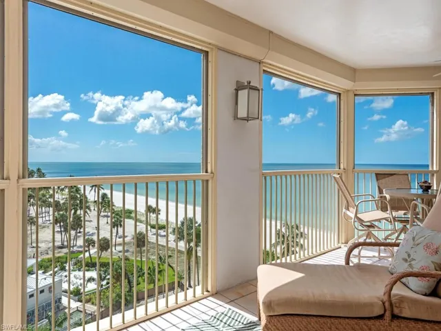 Balcony with view of water and beach and a sunroom