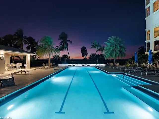 Community pool at sunset featuring a patio area