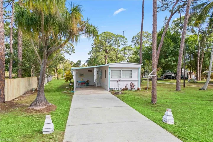 Charming home with beautiful extended driveway and mature and lush landscape.