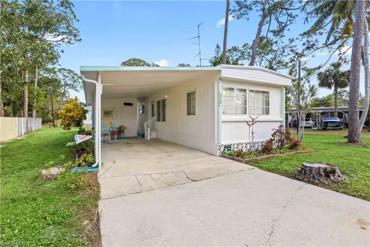 Long driveway welcomes you to an attached carport with laundry/workshop and a shower.  This area creates an additional outdoor living space to enjoy the beauty and weather of SWFL.