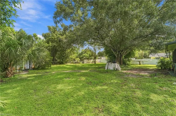 Expansive yard featuring mature trees and established landscaping