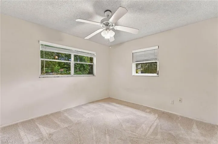 Wall-to-wall carpeting, dual windows, and a ceiling fan with integrated lighting