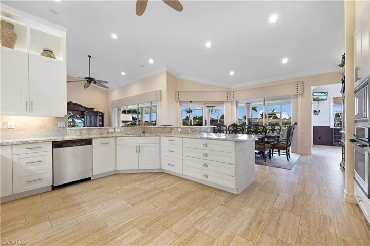 Kitchen featuring kitchen peninsula, ornamental molding, ceiling fan, and stainless steel appliances
