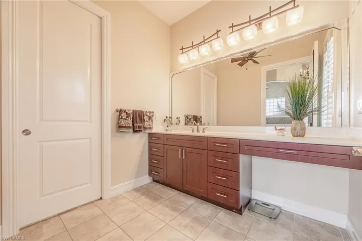 Bathroom featuring vanity, tile patterned flooring, and ceiling fan