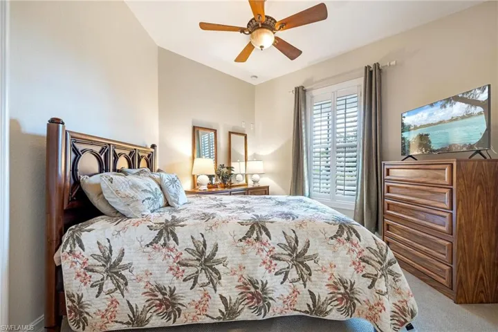 Carpeted bedroom featuring ceiling fan