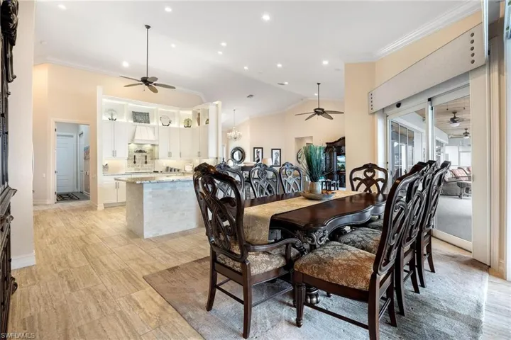 Dining space with lofted ceiling, crown molding, and ceiling fan