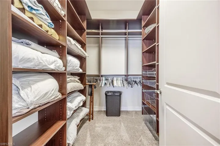 Spacious closet with light colored carpet