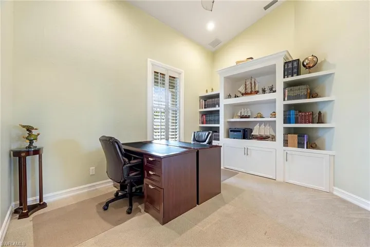 Office featuring light carpet and vaulted ceiling