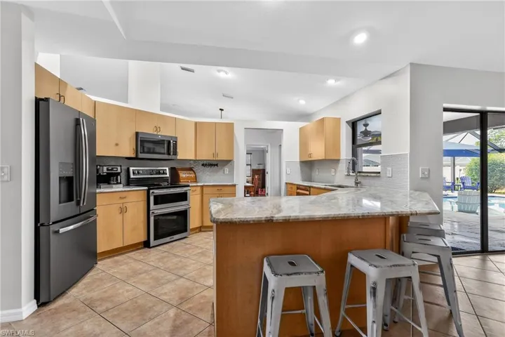 Updated kitchen with granite, stainless appliances and breakfast bar