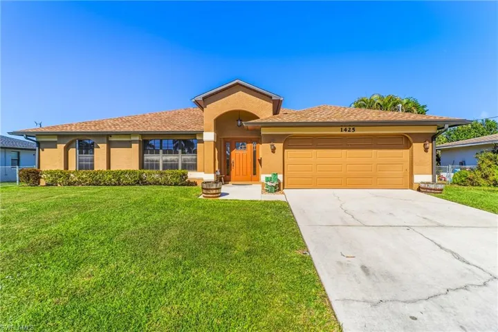 View of front of house with an attached garage, stucco siding, driveway, a front lawn, and a shingled roof