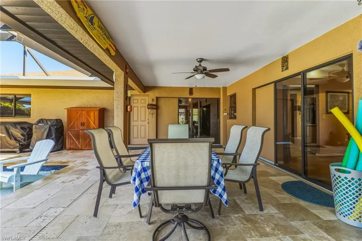 View of patio with ceiling fan and outdoor dining area