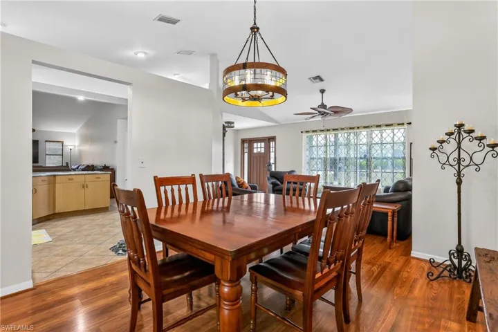 Dining room featuring lofted ceiling, laminate floors, and a ceiling fan