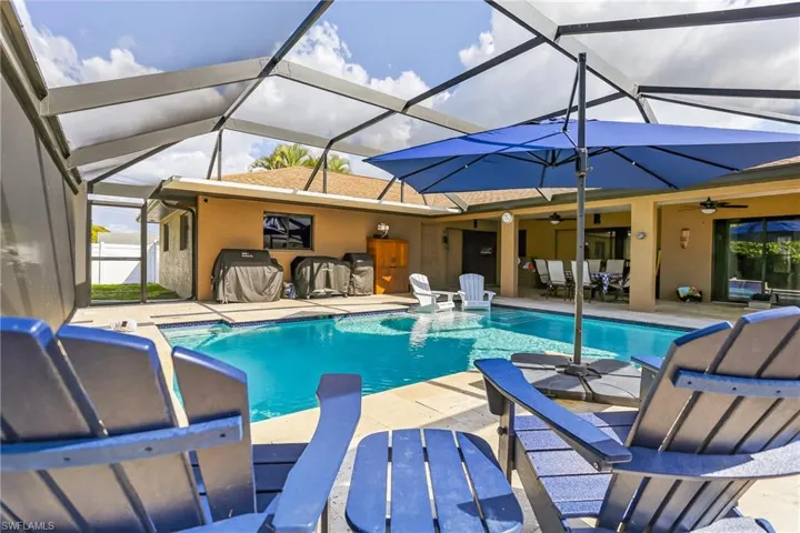 Outdoor pool featuring a travertine deck, picture window screen enclosure, and covered sitting area