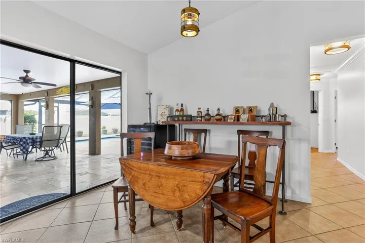 Dining space featuring lofted ceiling, ceiling fan, and light tile patterned flooring