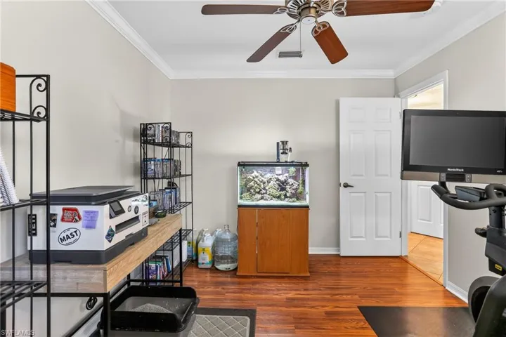 Den/ office featuring crown molding, laminate floors and ceiling fan