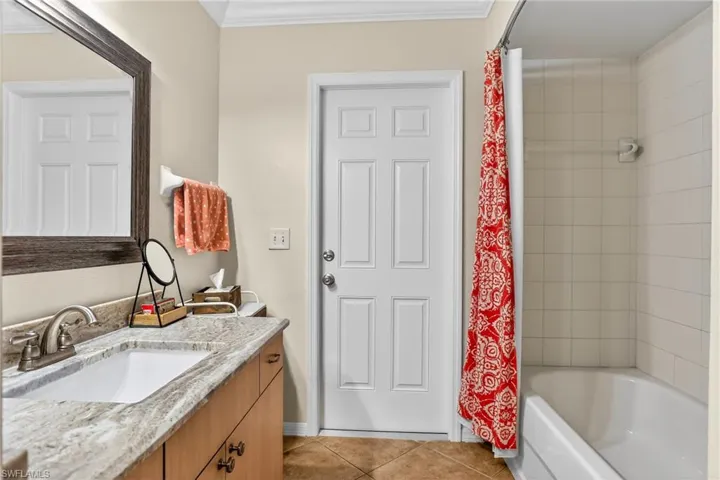 Bathroom with vanity, shower / tub combo, light tile patterned floors, and crown molding - Pool bath too!