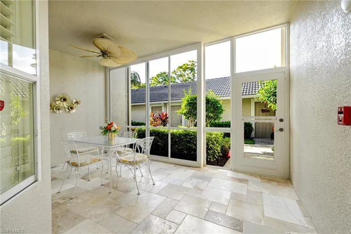Front lanai with enclosures and travertine floors. Table and chairs do convey