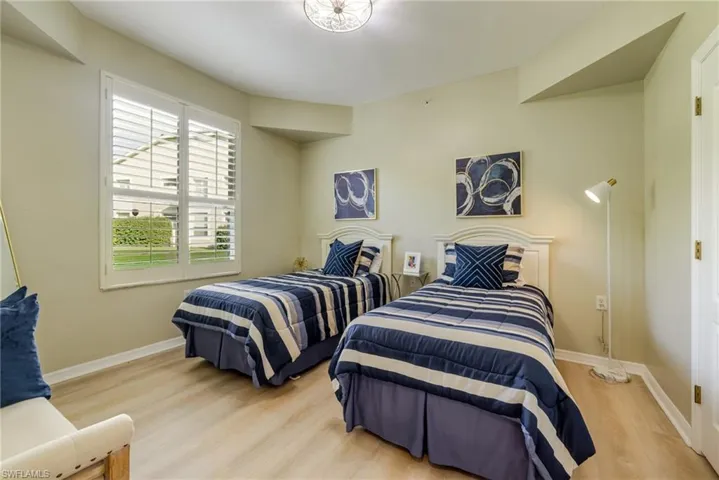 Guest bedroom with vinyl flooring and plantation shutters