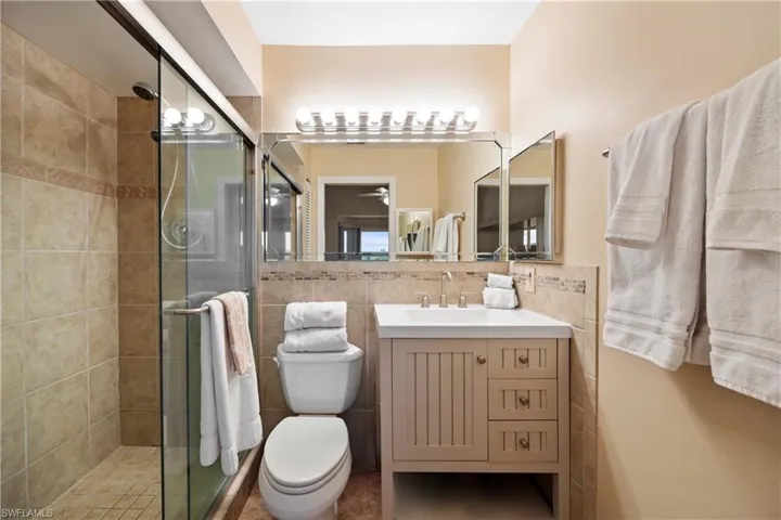 Bathroom with vanity, tile walls, and a stall shower