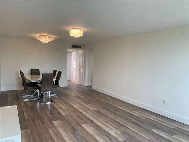 Dining area with dark wood-type flooring and baseboards