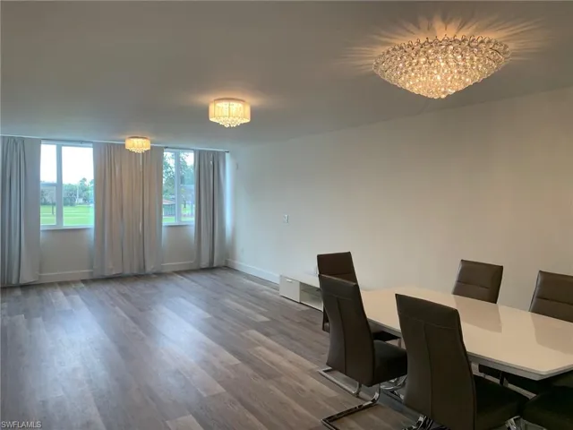 Dining area with dark wood-type flooring and a chandelier