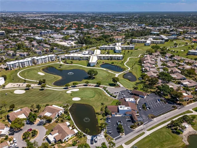Aerial overview of property's location with a golf course and a large body of water