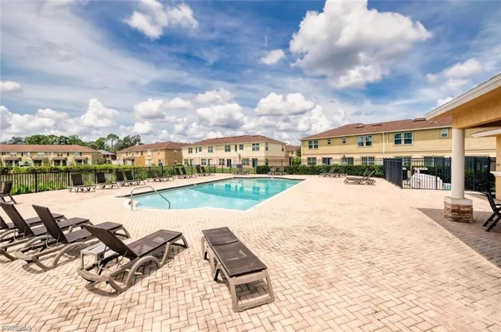 Expansive paver patio surrounding a community swimming pool with integrated steps