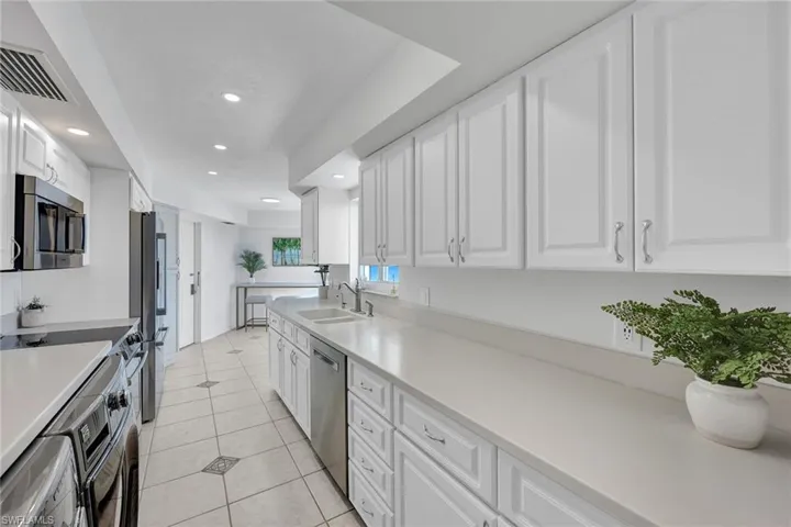 Crisp white kitchen with an entry door to the hall for easy grocery unpacking