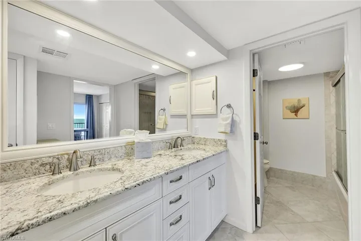 The crisp white primary ensuite bath includes three additional closets