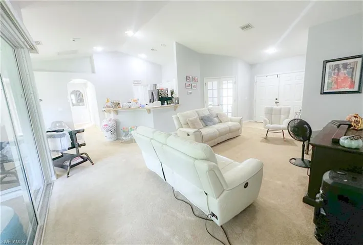 Carpeted living room featuring lofted ceiling