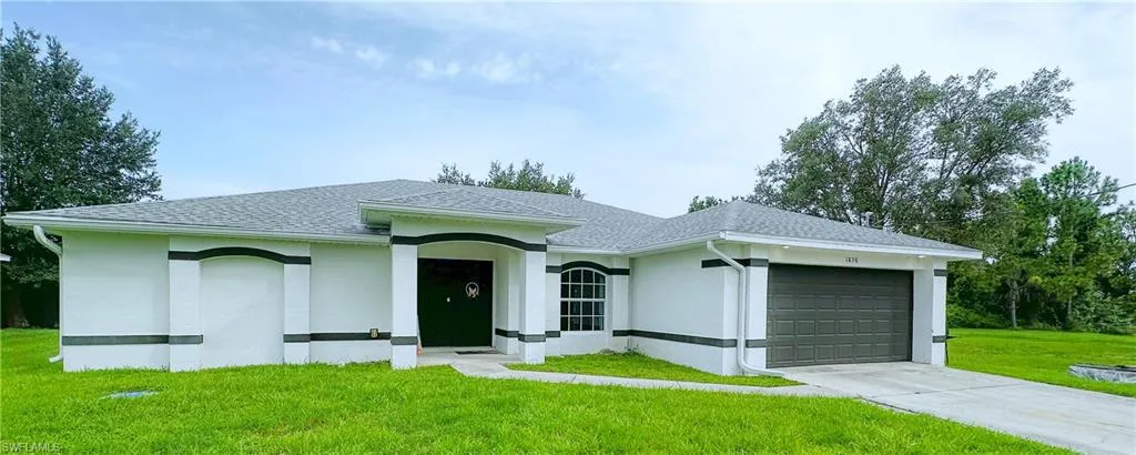 Ranch-style home with a garage and a front lawn