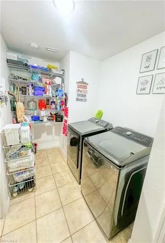 Washroom featuring separate washer and dryer and light tile patterned flooring