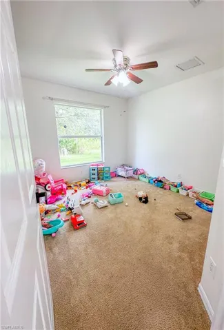 Rec room featuring ceiling fan and carpet flooring