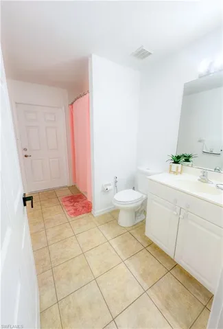 Bathroom with tile patterned floors, toilet, and vanity