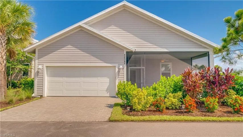 Back of house with a garage & screened lanail