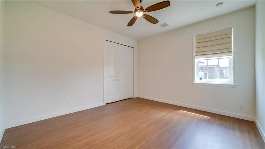 Guest Bedroom #1 features a large walk-in closet with closet system & a ceiling fan.