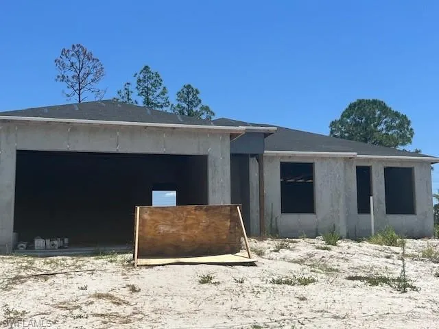 Property in mid-construction with stucco siding and a garage