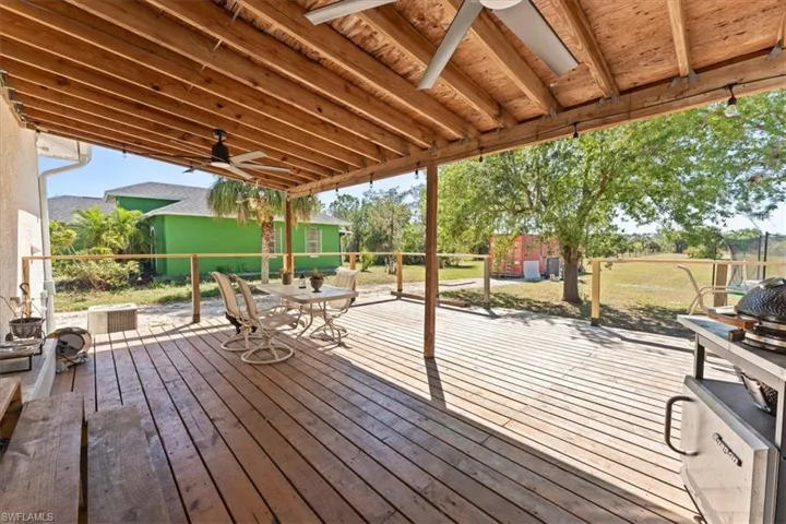 Deck featuring a lawn and ceiling fan