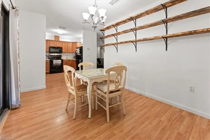 Dining room featuring visible vents, light wood-style floors, baseboards, and a chandelier
