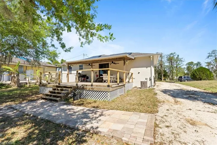 Back of house featuring a deck, stucco siding, and ceiling fan