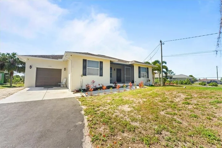 Ranch-style home with aphalt driveway, a garage, and stucco siding