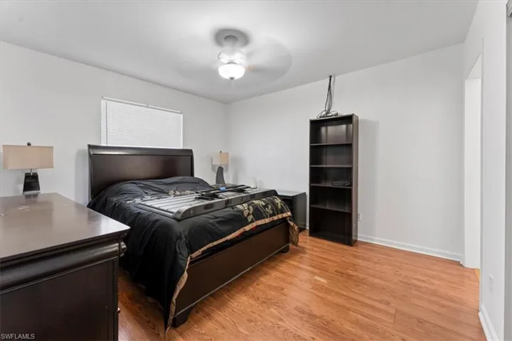 Bedroom featuring light wood-style flooring, a ceiling fan, and baseboards