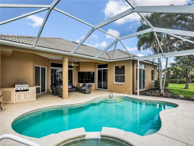 View of pool featuring a patio area, an outdoor hangout area, an outdoor kitchen, a pool with connected hot tub, and a ceiling fan