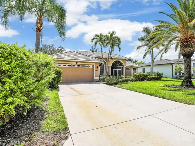 View of front of home featuring stucco siding, an attached garage, concrete driveway, a front yard, and a tiled roof