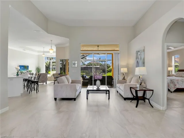 Living area with arched walkways and a towering ceiling