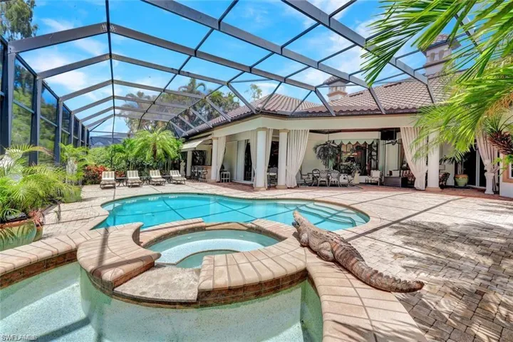 View of swimming pool with a lanai, an in ground hot tub, and a patio