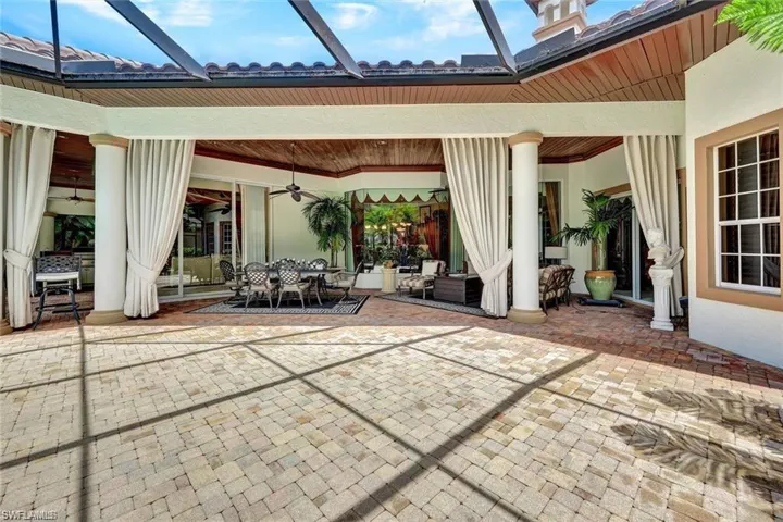 View of patio featuring glass enclosure and ceiling fan